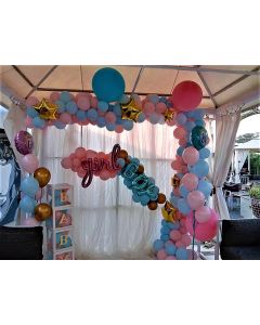 White cloth backdrop with pastel balloons arch and bunches with foils