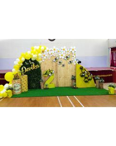 Honey bee concept wooden back drop with partial grass panel and yellow and white color balloons and paper flower arrangement
